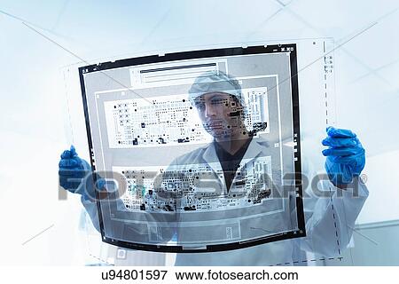 Stock Photo - Worker inspecting circuit board negative sheet in circuit board factory. Fotosearch