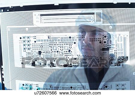 Stock Photograph - Worker inspecting circuit board negative sheet in circuit board factory. Fotosearch