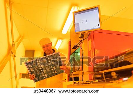 Worker inspecting circuit board under photographically safe light in circuit board factory View Large Photo Image Stock Photo - Worker inspecting circuit board under photographically safe light in circuit board factory. Fotosearch