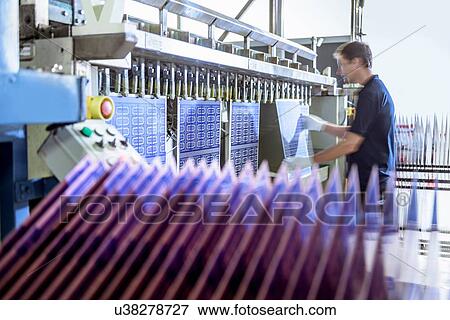 Worker loading circuit boards into processing machine in circuit board factory View Large Photo Image Stock Photo - Worker loading circuit boards into processing machine in circuit board factory. Fotosearch