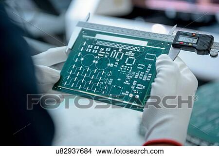 Worker measuring cut circuit board in circuit board factory, close up View Large Photo Image Picture - Worker measuring cut circuit board in circuit board factory, close up. Fotosearch