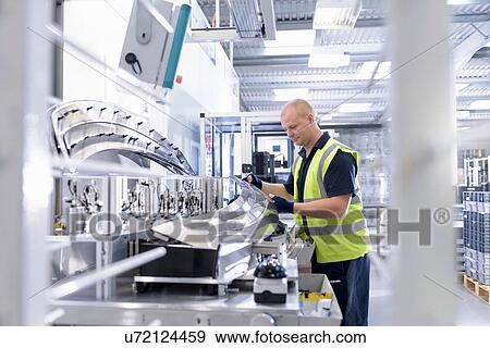 Worker using plastics welding rig in automotive parts spray paint factory View Large Photo Image Stock Photo - Worker using plastics welding rig in automotive parts spray paint factory. Fotosearch