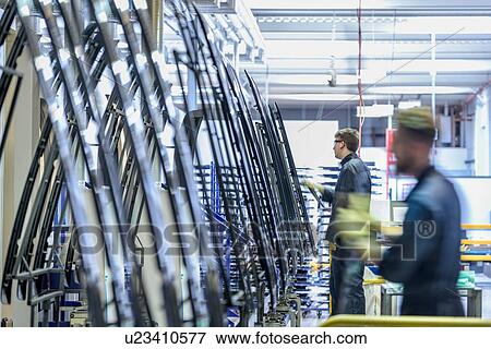 Stock Photo - Workers cleaning parts in automotive parts spray paint factory. Fotosearch