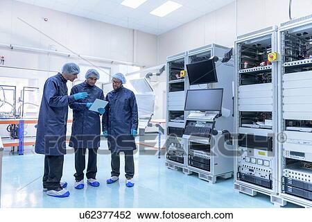 Stock Image - Workers in clean room in electronics factory. Fotosearch