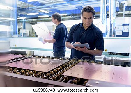 Workers inspecting circuit board during manufacture in circuit board factory View Large Photo Image Stock Photo - Workers inspecting circuit board during manufacture in circuit board factory. Fotosearch
