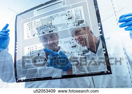 Stock Photo - Workers inspecting circuit board negative sheet in circuit board factory. Fotosearch