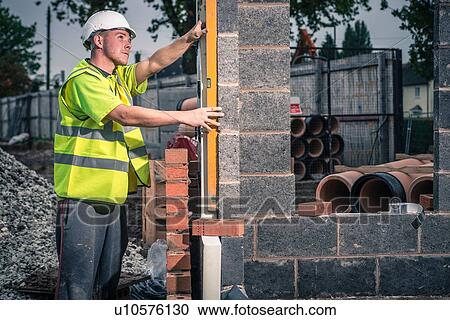 Workers laying bricks on construction site View Large Photo Image Stock Image - Workers laying bricks on construction site. Fotosearch