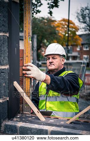 Workers laying bricks on construction site View Large Photo Image Stock Image - Workers laying bricks on construction site. Fotosearch