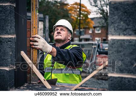 Workers laying bricks on construction site View Large Photo Image Stock Image - Workers laying bricks on construction site. Fotosearch