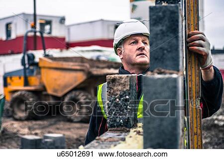 Workers laying bricks on construction site View Large Photo Image Stock Image - Workers laying bricks on construction site. Fotosearch