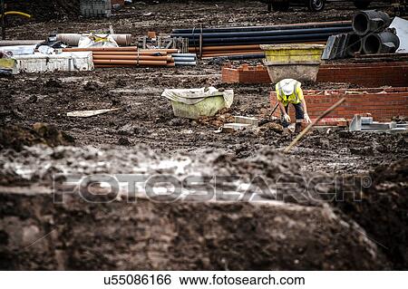 Stock Photograph - Workers laying bricks on construction site. Fotosearch
