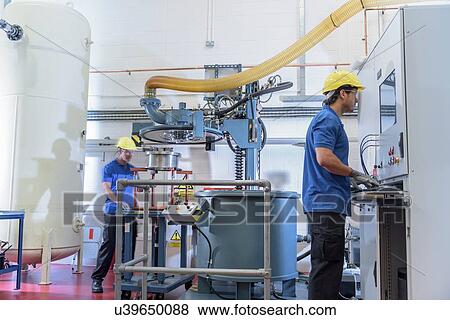 Workers operating environmental testing equipment in electronics factory View Large Photo Image Stock Photo - Workers operating environmental testing equipment in electronics factory. Fotosearch