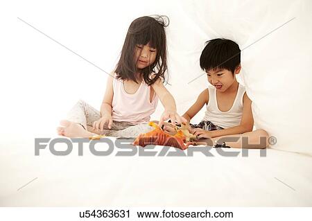 Young Chinese boy and girl in bed playing with their toys under the bedsheets View Large Photo Image Stock Image - Young Chinese boy and girl in bed playing with their toys under the bedsheets. Fotosearch