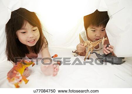 Young Chinese boy and girl in bed playing with their toys under the bedsheets View Large Photo Image Stock Image - Young Chinese boy and girl in bed playing with their toys under the bedsheets. Fotosearch
