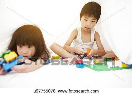 Young Chinese boy and girl in bed playing with their toys under the bedsheets View Large Photo Image Stock Photo - Young Chinese boy and girl in bed playing with their toys under the bedsheets. Fotosearch