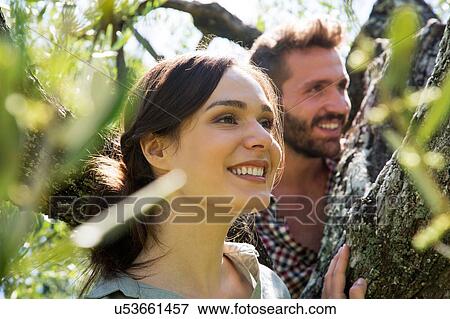 Young couple in tree looking away smiling View Large Photo Image Stock Photo - Young couple in tree looking away smiling. Fotosearch