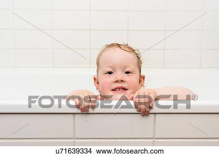 Young girl peering over edge of bathtub View Large Photo Image Picture - Young girl peering over edge of bathtub. Fotosearch