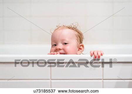 Young girl peering over edge of bathtub View Large Photo Image Stock Photo - Young girl peering over edge of bathtub. Fotosearch