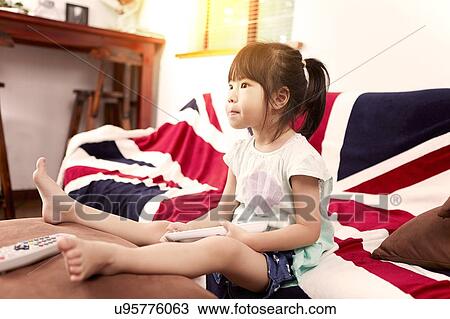 Young girl sitting on sofa watching the television at home View Large Photo Image Stock Image - Young girl sitting on sofa watching the television at home. Fotosearch