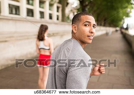 Young male runner looking over his shoulder on riverside View Large Photo Image Stock Photo - Young male runner looking over his shoulder on riverside. Fotosearch