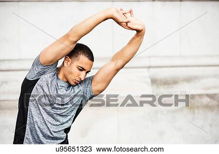 Young male runner warming up with hands raised View Large Photo Image Stock Image - Young male runner warming up with hands raised. Fotosearch