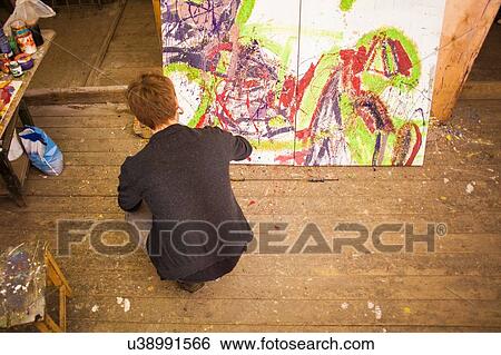 Young man painting on canvas in studio View Large Photo Image Stock Photograph - Young man painting on canvas in studio. Fotosearch
