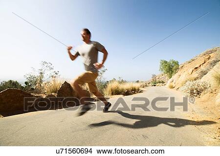 Picture - Young man, running, outdoors. Fotosearch
