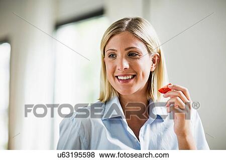Stock Photo - Young woman eating tomato sllice. Fotosearch