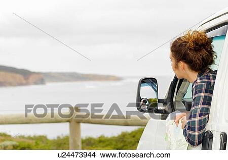 Picture - Young woman looking out from camper van window, Point Addis, Anglesea, Victoria, Australia. Fotosearch