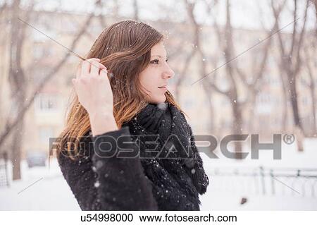 Young woman playing with her hair, wintry background View Large Photo Image Stock Image - Young woman playing with her hair, wintry background. Fotosearch