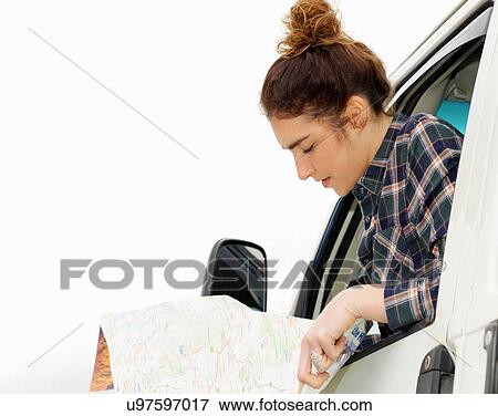 Young woman reading map from camper van window View Large Photo Image Stock Photo - Young woman reading map from camper van window. Fotosearch