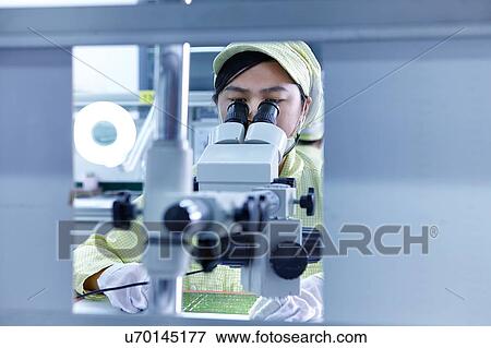 Young woman using microscope at quality check station at factory producing flexible electronic circuit boards. Plant is located in the south of China, in Zhuhai, Guangdong province View Large Photo Image Stock Photo - Young woman using microscope at quality check station at factory producing flexible electronic circuit boards. Plant is located in the south of China, in Zhuhai, Guangdong province. Fotosearch