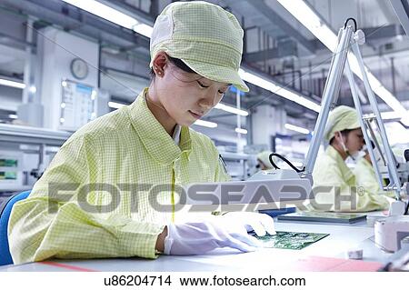 Young woman working at quality check station at factory producing flexible electronic circuit boards. Plant is located in the south of China, in Zhuhai, Guangdong province View Large Photo Image Picture - Young woman working at quality check station at factory producing flexible electronic circuit boards. Plant is located in the south of China, in Zhuhai, Guangdong province. Fotosearch