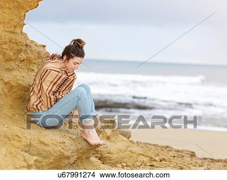 Young woman wrapped in shawl sitting on cliffside, Point Addis, Anglesea, Victoria, Australia View Large Photo Image Picture - Young woman wrapped in shawl sitting on cliffside, Point Addis, Anglesea, Victoria, Australia. Fotosearch