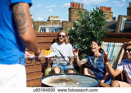 Adult friends raising a toast at rooftop party View Large Photo Image Stock Image - Adult friends raising a toast at rooftop party. Fotosearch