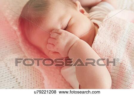 Stock Photo - Baby covering eye in sleep. Fotosearch