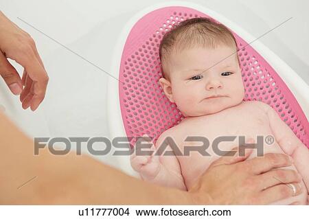 Baby lying in bouncer View Large Photo Image Picture - Baby lying in bouncer. Fotosearch