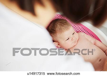 Stock Photography - Baby lying in bouncer. Fotosearch