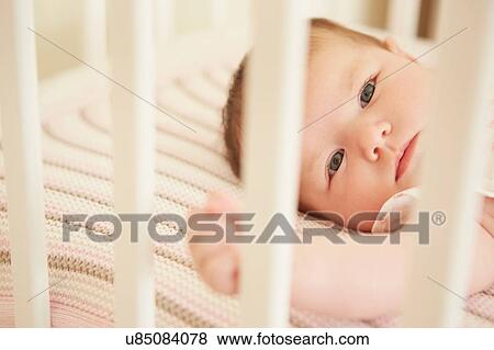 Baby lying in crib View Large Photo Image Stock Photo - Baby lying in crib. Fotosearch