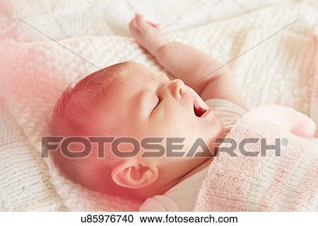 Stock Image - Baby yawning in sleep. Fotosearch
