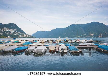 Stock Photo - Boats moored in harbor, Lake Lugano, Switzerland. Fotosearch