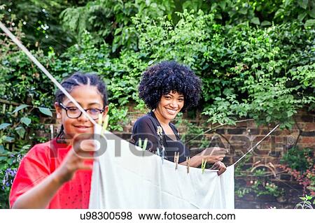 Boy and mother pegging sheets on garden clothesline View Large Photo Image Stock Photo - Boy and mother pegging sheets on garden clothesline. Fotosearch