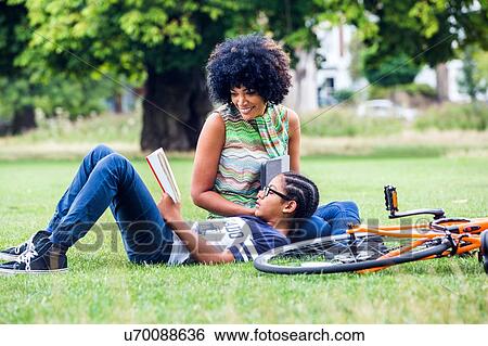 Stock Photograph - Boy and mother reading and relaxing in park. Fotosearch
