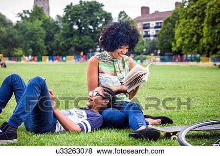 Boy and mother relaxing and reading book in park View Large Photo Image Stock Photo - Boy and mother relaxing and reading book in park. Fotosearch