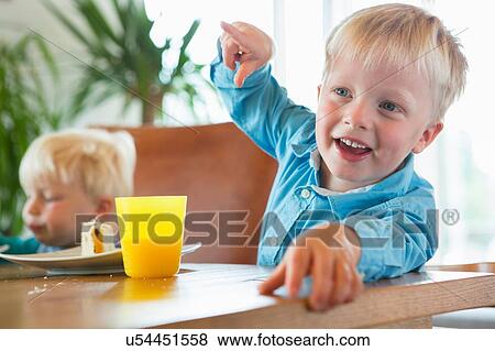 Boy and toddler brother at tea table View Large Photo Image Stock Photo - Boy and toddler brother at tea table. Fotosearch