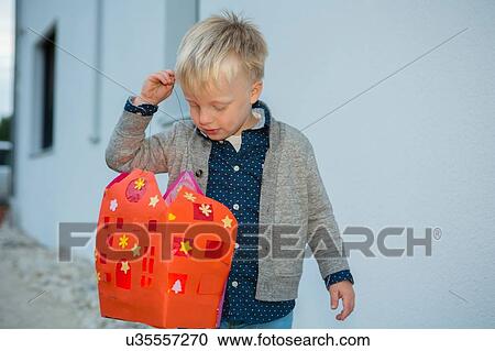 Boy carrying home made xmas lantern on patio View Large Photo Image Stock Image - Boy carrying home made xmas lantern on patio. Fotosearch