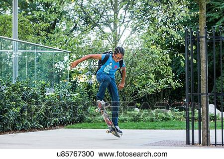 Boy doing skateboarding trick on urban sidewalk View Large Photo Image Stock Image - Boy doing skateboarding trick on urban sidewalk. Fotosearch