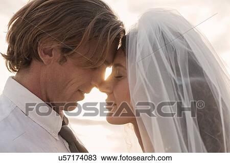 Bride and groom, face to face, outdoors, sunset View Large Photo Image Stock Image - Bride and groom, face to face, outdoors, sunset. Fotosearch