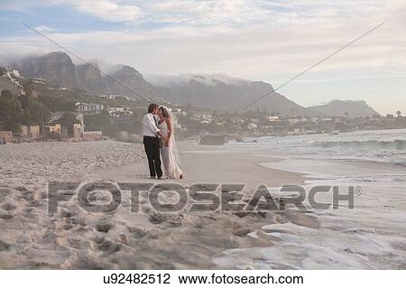 Bride and groom on beach, standing face to face View Large Photo Image Stock Image - Bride and groom on beach, standing face to face. Fotosearch