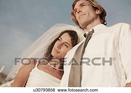 Stock Photo - Bride leaning on groom's shoulder. Fotosearch
